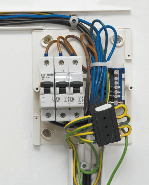 Небольшой щиток на 3 автомата со снятой панелью: провода заземления соединены вместе при помощи специальной клеммы, нолевые (синего цвета) — при помощи шины, расположенной справа от автоматов